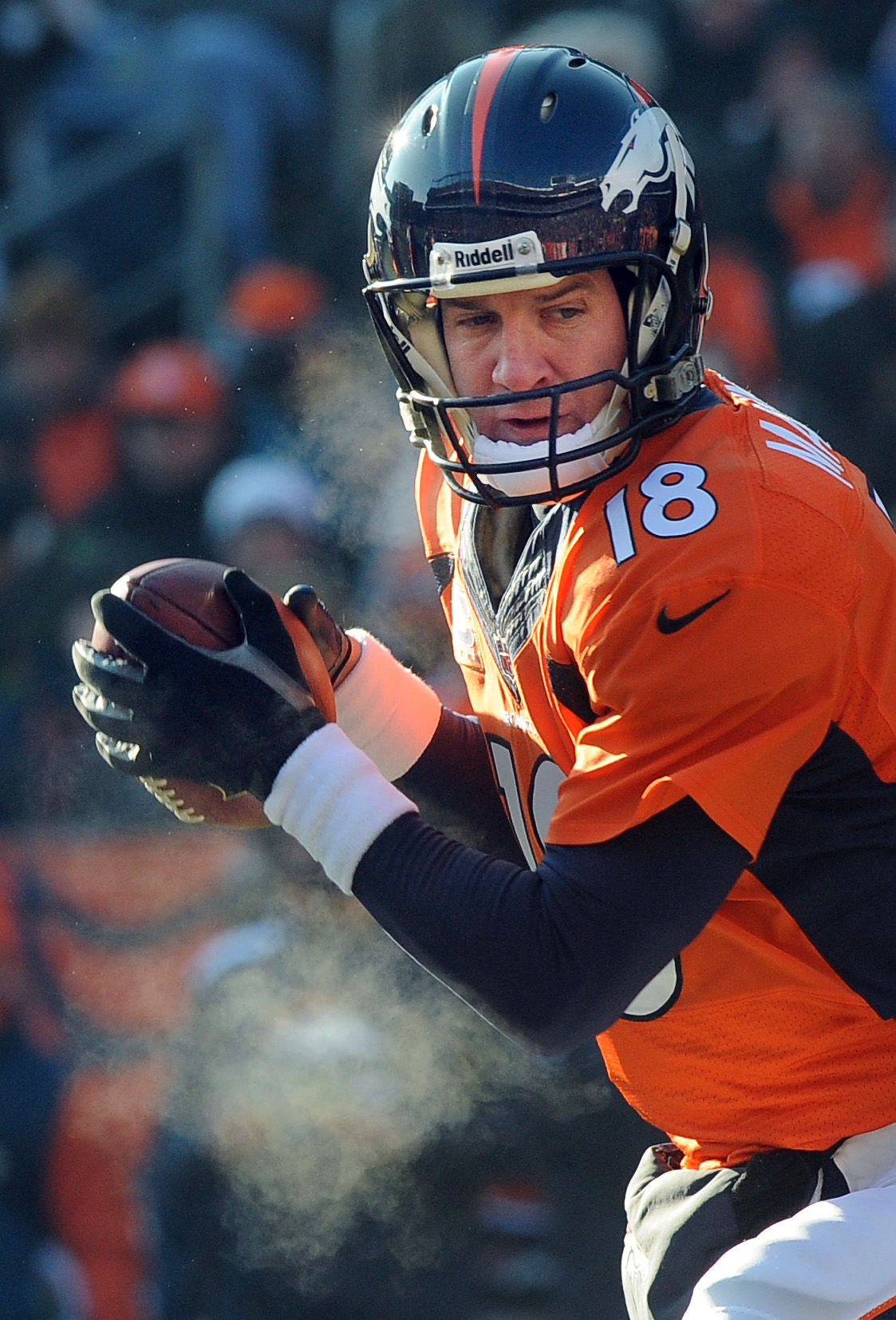 Broncos quarterback Peyton Manning's breath can be seen before handing off the ball during the first quarter of a game against the Tennessee Titans. The Broncos played the Titans at Invesco Field at Mile High Stadium on Sunday, December 8, 2013. . (The Gazette/Jerilee Bennett)